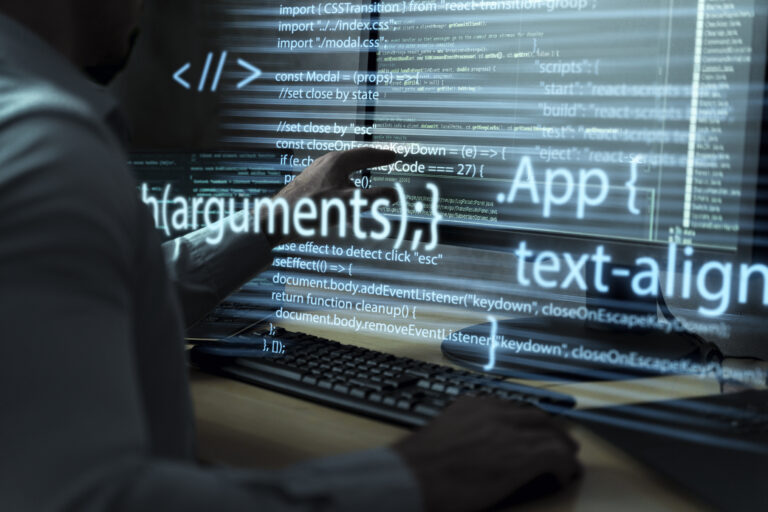 Developer working with code on multiple screens, representing the new features and reactivity improvements in Angular v20.